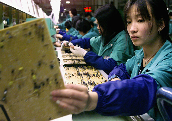 Workers inspect data boards at an assembly line at