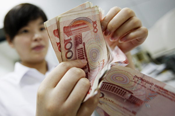 A Chinese bank worker counts stacks of 1