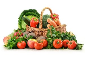 Raw vegetables and wicker basket isolated on white