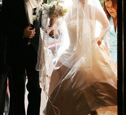A groom and a bride enter a church in do