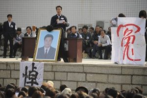 2011年12月16日，乌坎村民举行集会及为被打死村民代表薛锦波办追悼会。中间站立在薛锦波遗照后者为林祖銮