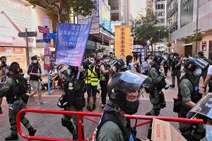 香港防暴警察突发冲到法轮功摊位后再离开。